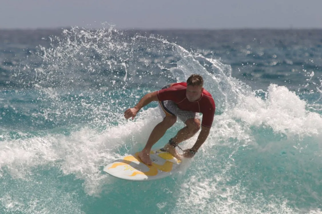 Surfer riding wave in tropical paradise
